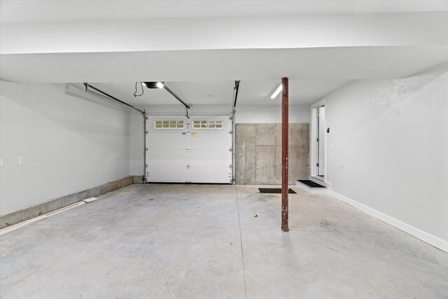 garage featuring a garage door opener and baseboards