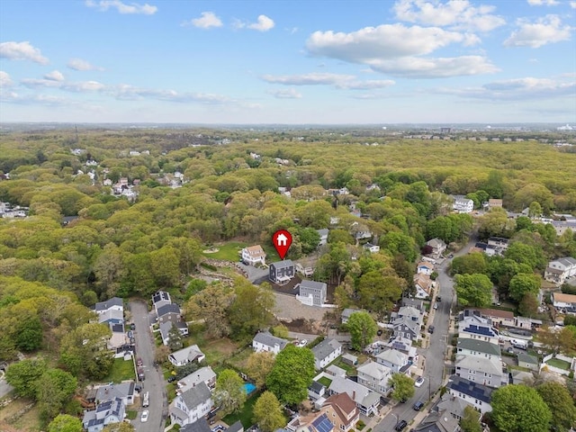 aerial view of property's location with a forest and nearby suburban area