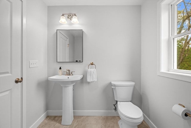 bathroom with toilet and baseboards
