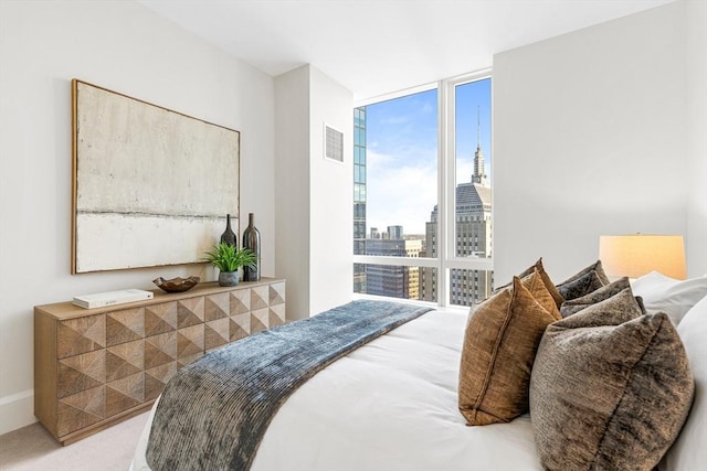 carpeted bedroom with a wall of windows