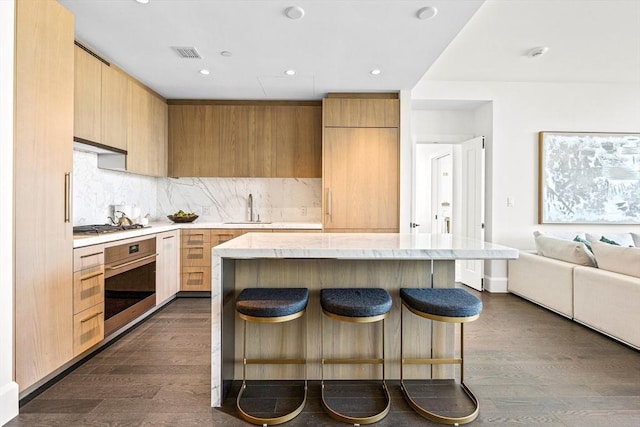 kitchen featuring stainless steel appliances, dark hardwood / wood-style floors, a center island, and sink