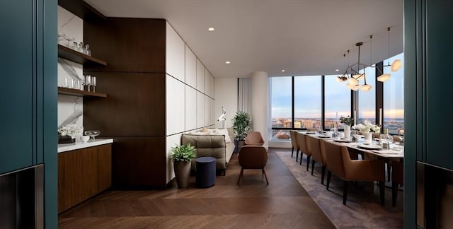 kitchen featuring white cabinetry, hanging light fixtures, and dark parquet flooring