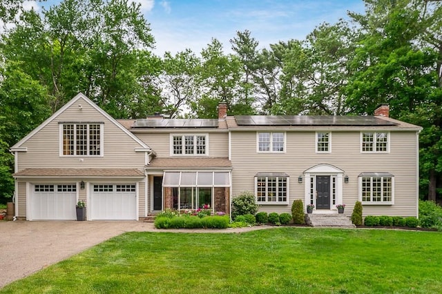 5 Whipple Rd, Hamilton, MA 01982 - view of front of property featuring a chimney, driveway, a front lawn, and roof mounted solar panels