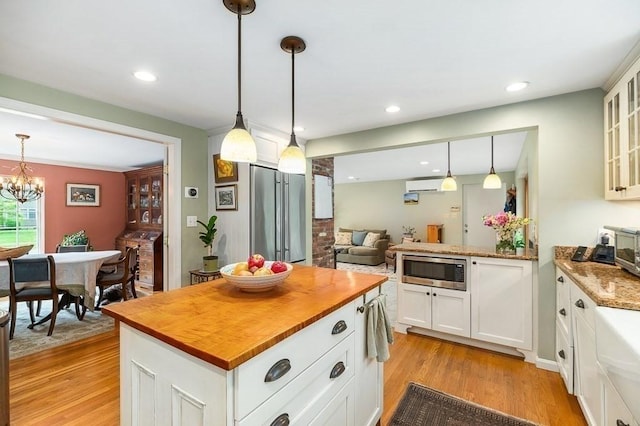 5 Whipple Rd, Hamilton, MA 01982 - kitchen with appliances with stainless steel finishes, an AC wall unit, wood counters, light wood finished floors, and glass insert cabinets
