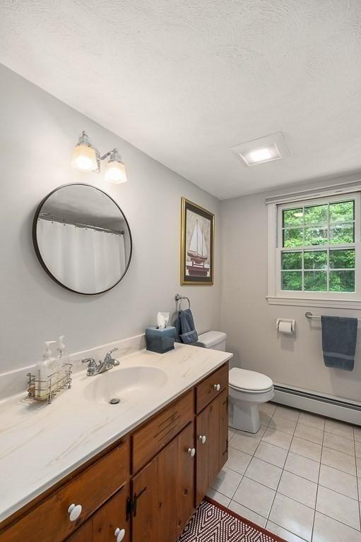 5 Whipple Rd, Hamilton, MA 01982 - full bath with a baseboard heating unit, vanity, tile patterned floors, and a textured ceiling