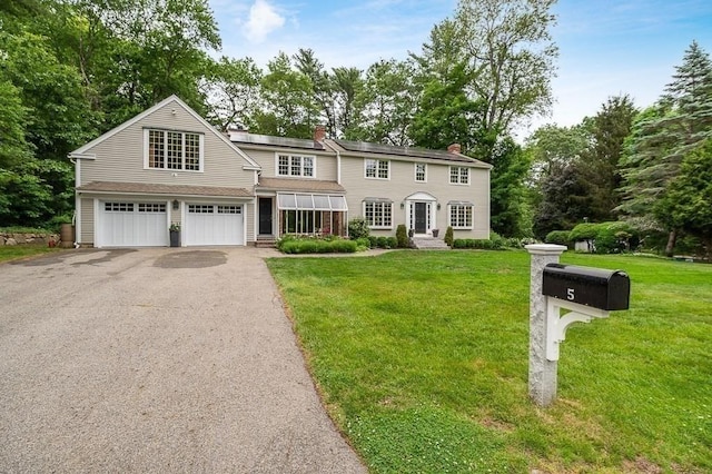 5 Whipple Rd, Hamilton, MA 01982 - view of front of house featuring asphalt driveway, a front yard, a chimney, and a garage