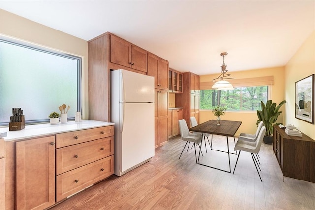 73 Mountain Gate Rd Unit 73, Ashland, MA 01721 - kitchen featuring freestanding refrigerator, light wood-style floors, decorative light fixtures, glass insert cabinets, and light countertops