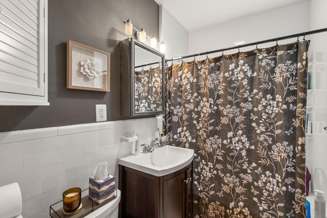 bathroom with tile walls, toilet, and vanity