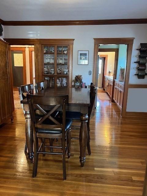 dining room with hardwood / wood-style floors and crown molding