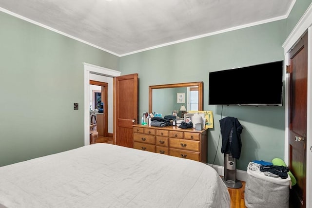 bedroom featuring ornamental molding and hardwood / wood-style floors