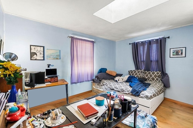 bedroom with hardwood / wood-style floors and a skylight