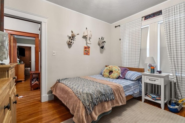 bedroom featuring crown molding and wood-type flooring