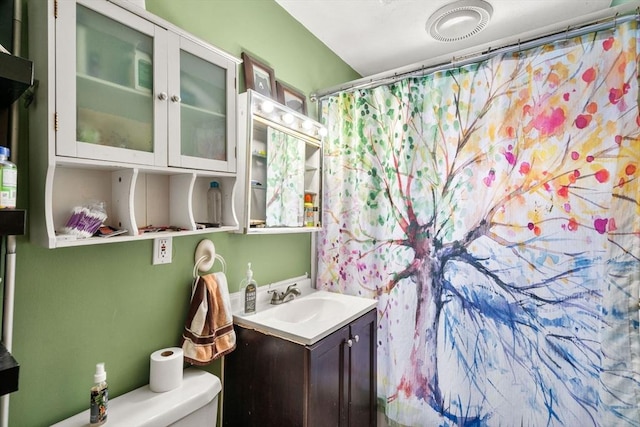 bathroom featuring vanity, toilet, and a shower with curtain