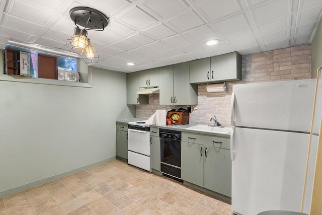 kitchen with white appliances, tasteful backsplash, green cabinetry, sink, and pendant lighting