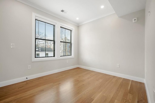 empty room featuring crown molding and light hardwood / wood-style flooring