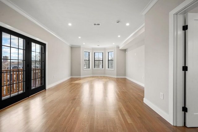 spare room featuring light hardwood / wood-style flooring and ornamental molding