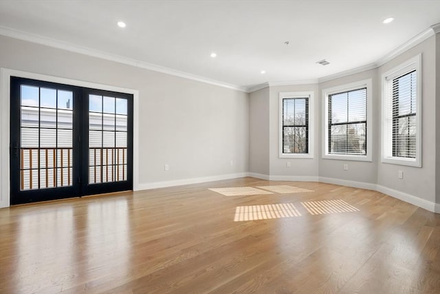 spare room featuring light hardwood / wood-style floors, crown molding, and a wealth of natural light