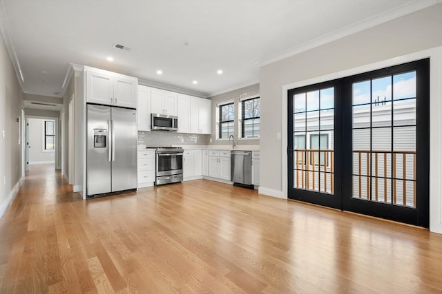 kitchen with white cabinets, stainless steel appliances, and light hardwood / wood-style floors