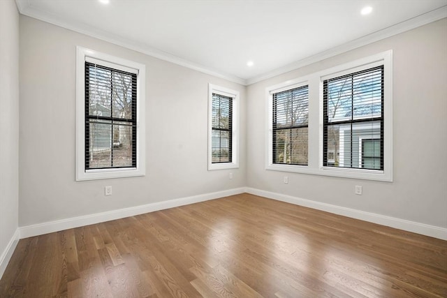 spare room featuring wood-type flooring and ornamental molding