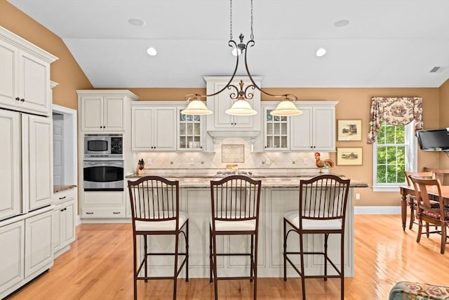 28 Ridgewood Xing Unit 28, Hingham, MA 02043 - kitchen with appliances with stainless steel finishes, lofted ceiling, tasteful backsplash, a breakfast bar, and a center island