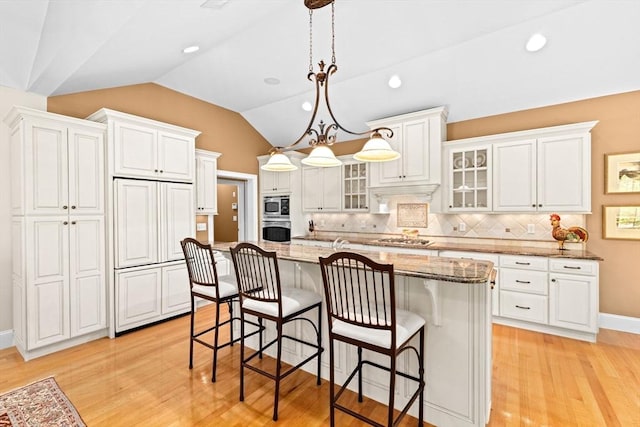 28 Ridgewood Xing Unit 28, Hingham, MA 02043 - kitchen featuring stainless steel appliances, light wood-style flooring, white cabinets, lofted ceiling, and a kitchen breakfast bar