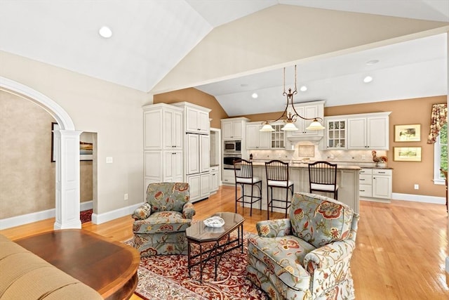 28 Ridgewood Xing Unit 28, Hingham, MA 02043 - living room with lofted ceiling, arched walkways, light wood finished floors, recessed lighting, and ornate columns