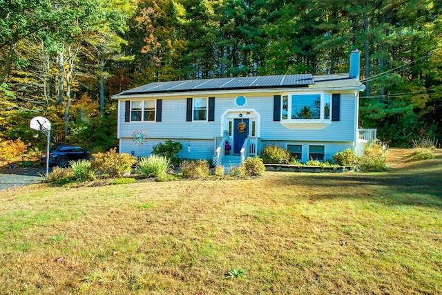 bi-level home with solar panels and a front lawn