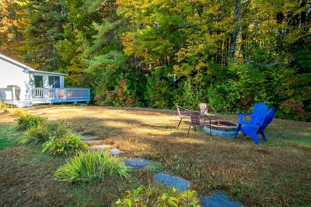 view of yard featuring a wooden deck and an outdoor fire pit