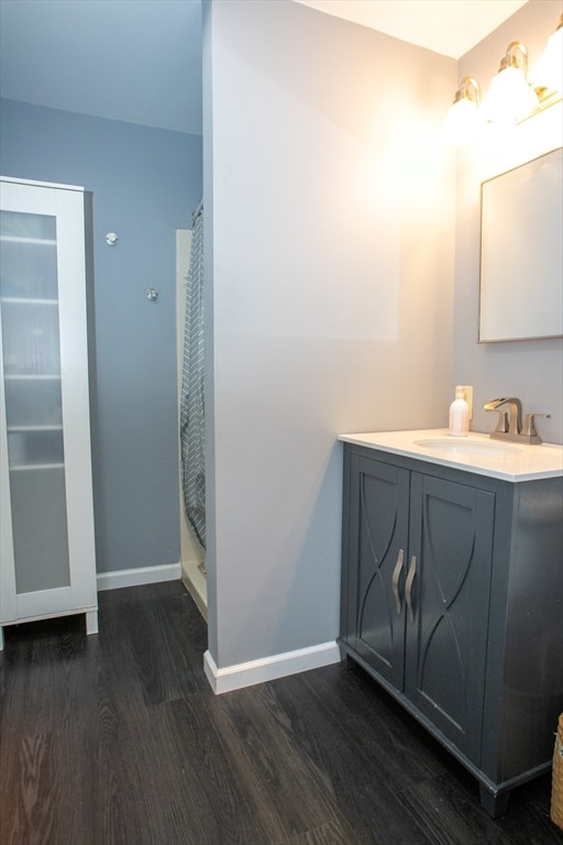 bathroom with hardwood / wood-style flooring, vanity, and a shower with curtain