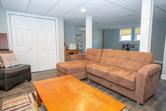 living room featuring a drop ceiling and dark hardwood / wood-style floors