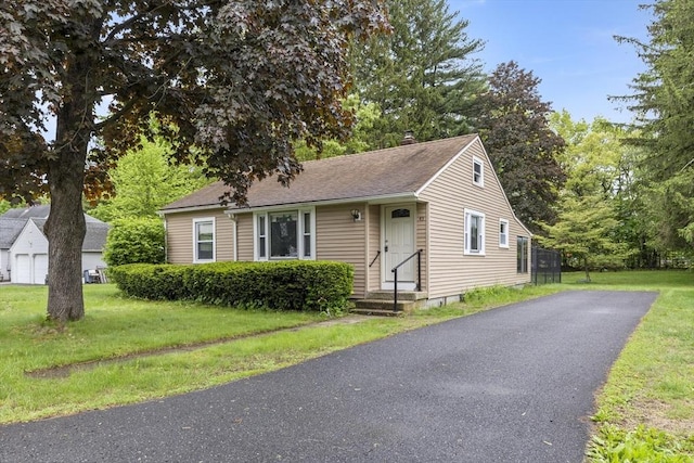 43 Pleasantview St, Ludlow, MA 01056 - view of front of house with asphalt driveway, a front lawn, a chimney, and roof with shingles