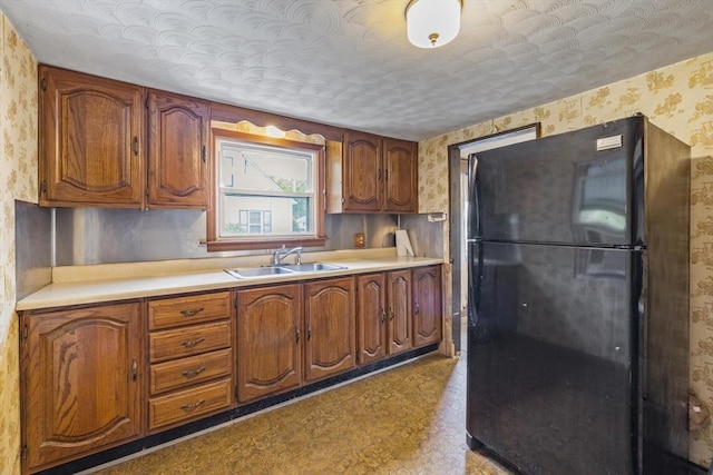 43 Pleasantview St, Ludlow, MA 01056 - kitchen with freestanding refrigerator, a sink, wallpapered walls, and brown cabinets