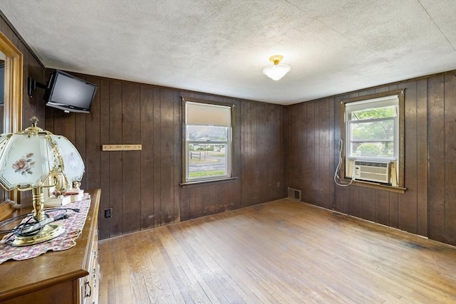 43 Pleasantview St, Ludlow, MA 01056 - unfurnished room with cooling unit, hardwood / wood-style floors, a textured ceiling, and wood walls