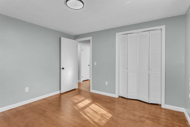 unfurnished bedroom featuring a closet and light wood-type flooring