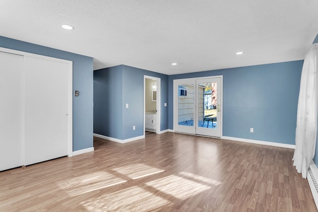 unfurnished room with a textured ceiling and light hardwood / wood-style flooring