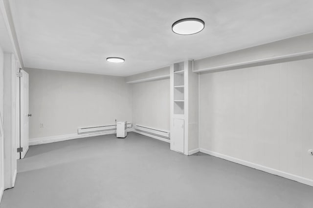 unfurnished room featuring concrete floors and baseboard heating