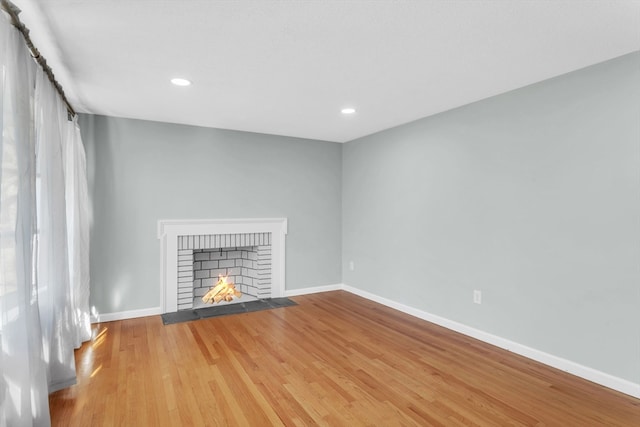 unfurnished living room featuring wood-type flooring and a fireplace