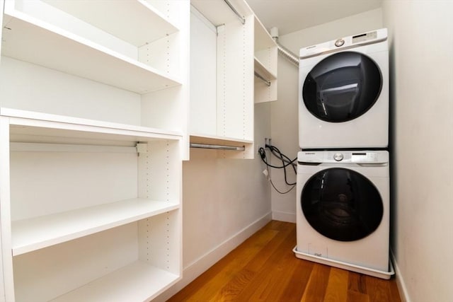 laundry room featuring stacked washer / dryer and hardwood / wood-style flooring