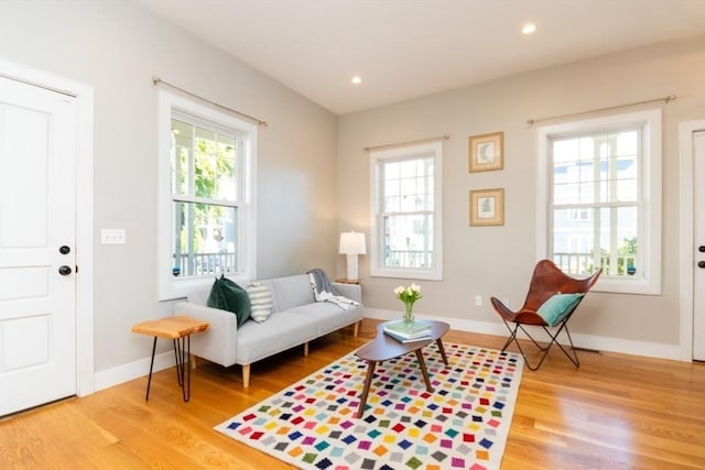 sitting room with hardwood / wood-style flooring and a healthy amount of sunlight