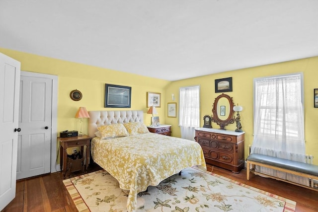 bedroom with radiator heating unit and wood-type flooring