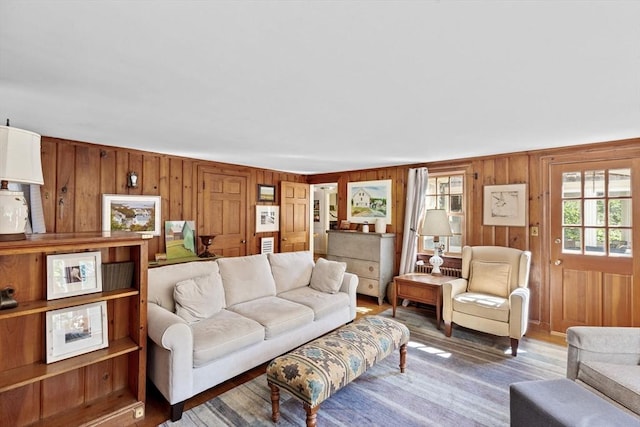 living area with wood walls and light wood finished floors