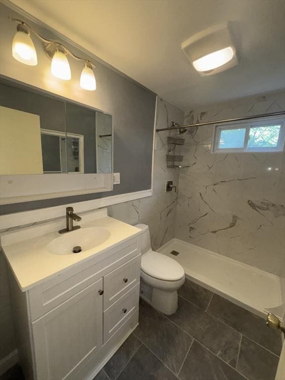 bathroom featuring toilet, vanity, and a stall shower