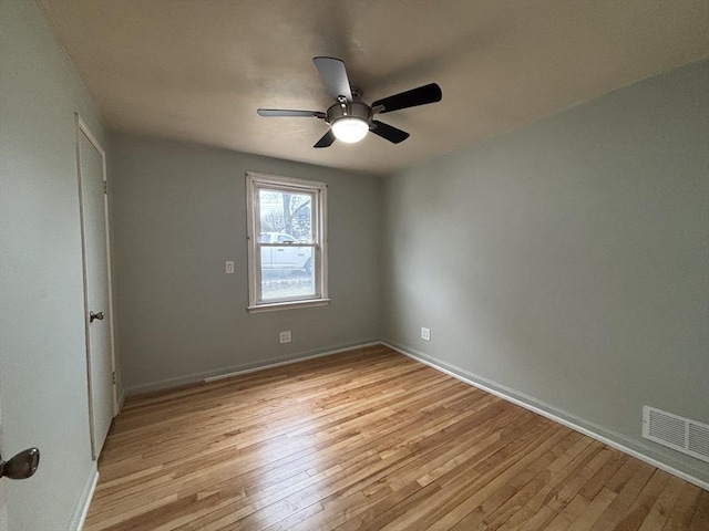 empty room with ceiling fan, baseboards, visible vents, and light wood-style floors
