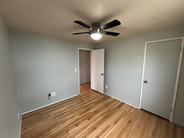 unfurnished bedroom featuring baseboards, light wood-style flooring, and a ceiling fan