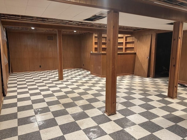 finished below grade area with bar, light floors, and wood walls