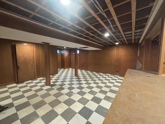 finished below grade area featuring light floors and wooden walls