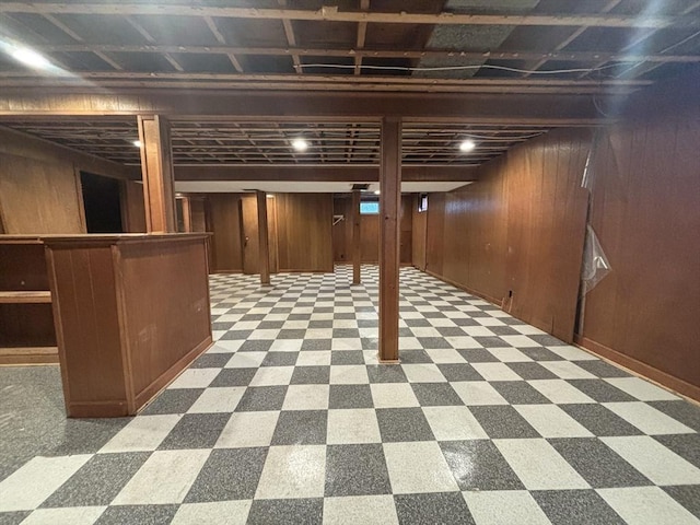 finished below grade area with wood walls and tile patterned floors