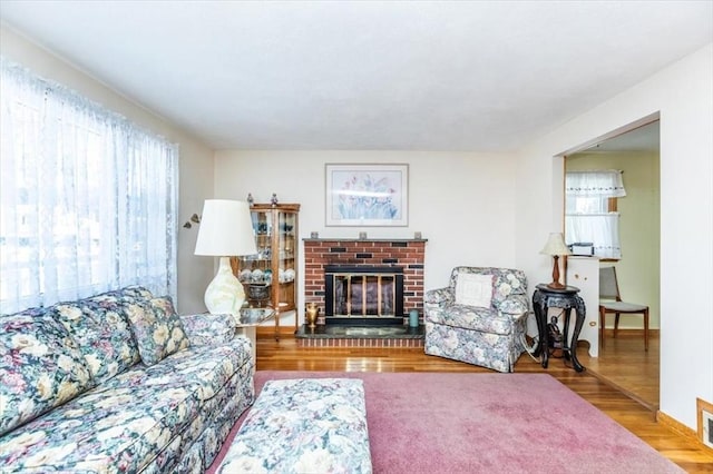 living room with hardwood / wood-style flooring, a fireplace, and a wealth of natural light