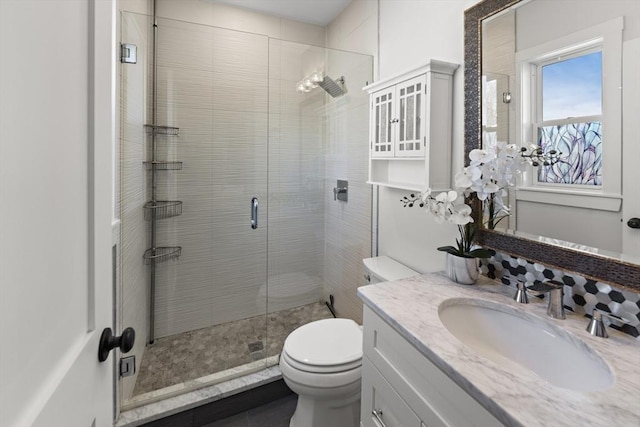 bathroom with vanity, toilet, and a stall shower