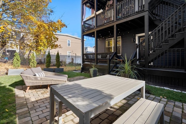 view of patio with a wooden deck, stairs, and fence